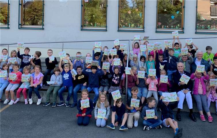 Auf Augenhöhe mit den Schülerinnen und Schülern der Grundschule am Sonnenberg in Unkel: Stadtbürgermeister Gerhard Hausen und Dr. Meinolf Gerstkamp, Vorstandsmitglied des Rotary Clubs Remagen-Sinzig. Beide überreichten den Mädchen und Jungen mit ihrer stellvertretenden Schulleiterin Tanja Kock vor Ort die Lehrmaterialien. Foto: Thomas Herschbach