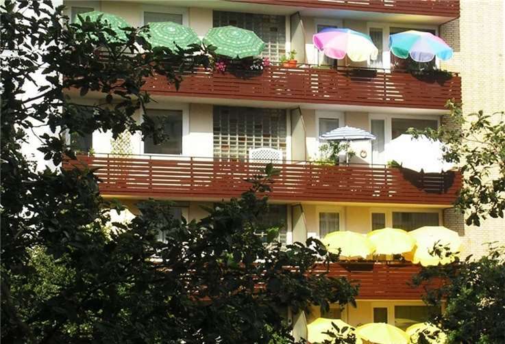 Auf dem Balkon verschafft ein geöffneter Sonnenschirm den Fensterflächen Schatten.  Foto: Hermann Obermeyer