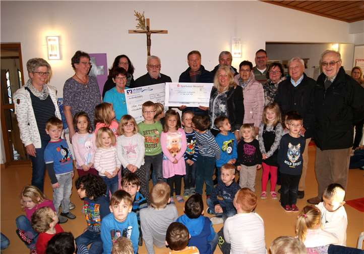 Auf dem Bild Frau Glinka (3.v.li.), Frau Wendt (4.v.li.), Hilmar Korb ( 5.v.li.) und Rudi Runkel (6.v.li.), KiTa-Erzieherinnen, Sängerinnen und Sänger des Irlicher Chors im Kreis der Tagesstätten - Kinder.“Cäcilia“Irlich