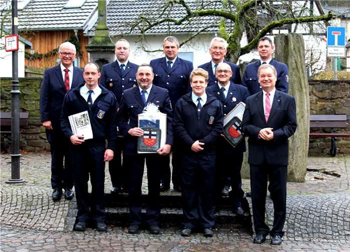 Auf dem Dorfplatz stellten sich die beförderten, verpflichteten und geehrten Feuerwehrleute zum Gruppenfoto auf.-dl