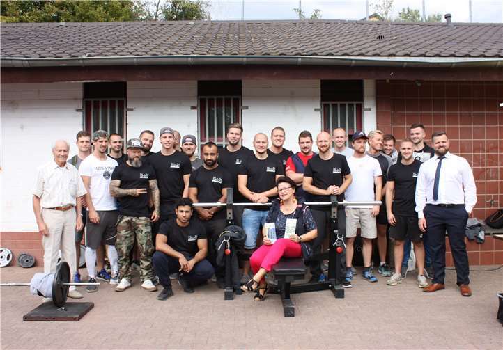 Auf dem Germaniasportplatz in Neuwied kamen Sportler der „Muckibude“ zusammen, um möglichst viele Kilos zugunsten der Hospizarbeit im Kreis Neuwied zu stemmen. Horst Roth (l.) und Dr. Ingrid Stollhof (sitzend) vom Neuwieder Hospizverein dankten den Sportlern für diese besondere Aktion. Unterstützung gab es von Deutschlands „breitestem Pastor“, Marcus Schneider (5. v.l.).Hospizverein