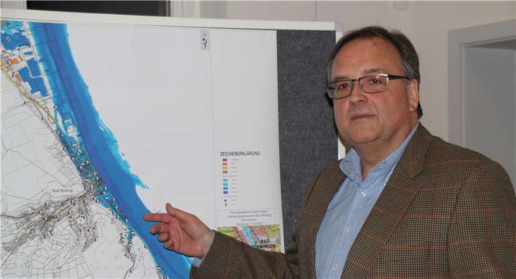 Auf dem Hochwasser-Workshop: Verbandsbürgermeister Bernd Weidenbach vor einer Grafik, die die Auswirkung eines Jahrhunderthochwassers auf das Rheinufer in Bad Breisig und Brohl-Lützing demonstriert.
