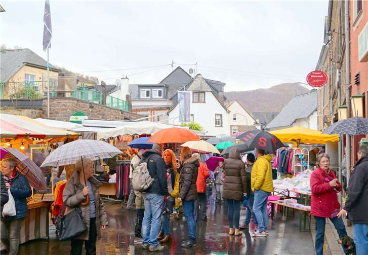 Auf dem Marktplatz dominierten in diesem Jahr die Regenschirme: Eingefleischten Katharinenmarkt-Besuchern machen Wind und Wetter aber wenig aus. Sie treffen sich mit Freunden zum Kaufen und Reden.TT