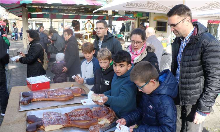 Auf dem Marktplatz in Bad Neuenahr werden ein Riesenweckmann und eine Riesenweckfrau portionsweise verteilt.Aktivkreis Bad Neuenahr