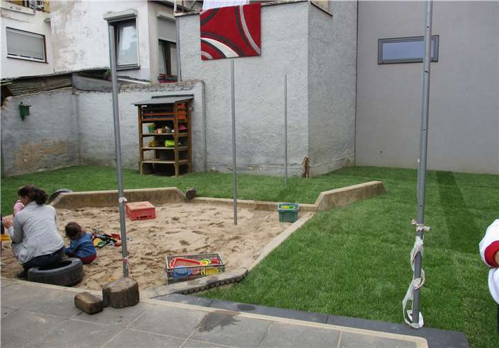 Auf dem oberen Außengelände entstand eine Rasenfläche mit einem begrenzten Sandkasten. Foto: privat