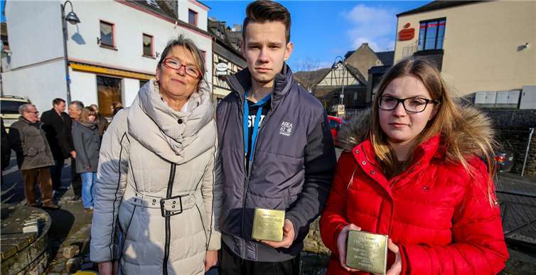 Auf den Stolpersteinen in den Händen der Schüler (mit Projektleiterin Anette Schröter) sind Gedenktafeln aus Messing befestigt, auf denen die Namen der ermordeten Juden zu lesen sind.