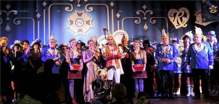 Auf der Bühne das Tollitätenpaar mit seinem Hofstaat. Die Paginnen werden flankiert von Otto Fischer (l.) und Bernd Müller. BSB