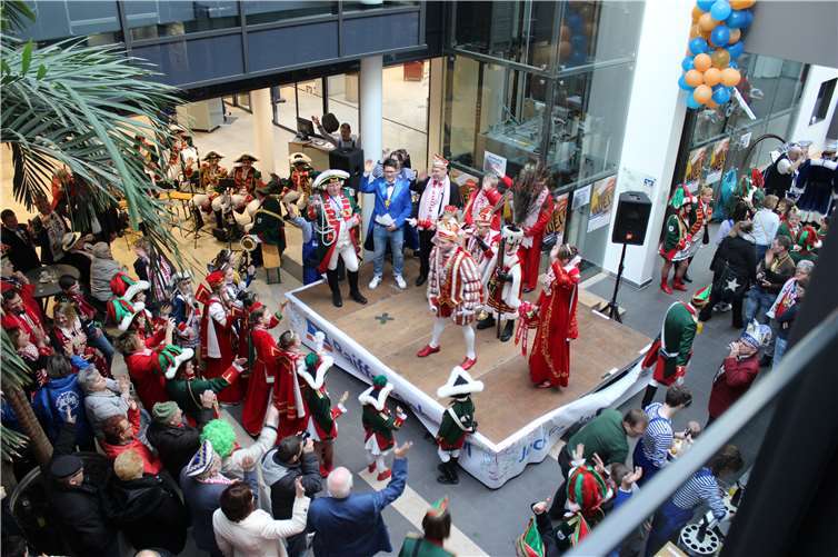 Auf der Bühne (v. l. n. r.): Moderatoren Rainer Thelen von den Stadtsoldaten Rheinbach und Marcel Richter, Marktbereichsleiter der Raiffeisenbank Voreifel. Von der KG Gemütlichkeit Dom-Esch e. V. Das Kinderdreigestirn: Prinz Philipp I, Jungfrau Dana und Bauer Max sowie Prinzenpaar Karsten I und Simone I und Gefolge.