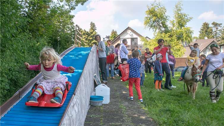 Auf der Rollenrutsche stützen sich die Kinder mutig in die Tiefe.