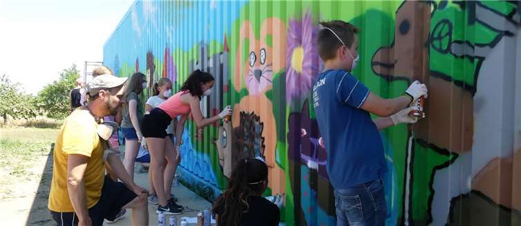 Auf der Rückwand der Betriebshalle von Familie Berens zauberten die Kids mittels Farbsprühdosen ein Landschaftsbild. Fotos: TE