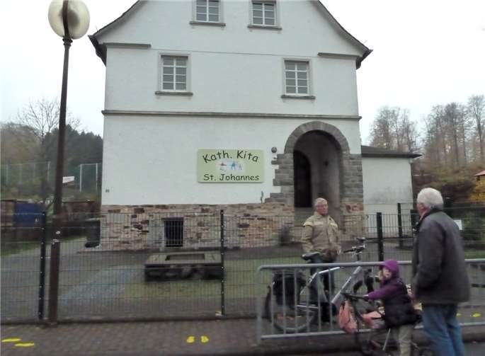 Auf der Straße vor der wegen schädlicher Emissionen geschlossenen Kindertagesstätte St. Johannes in Horressen diskutieren Bürger aufgebracht über die Missstände dort, die angeblich schon lange bekannt waren. KER