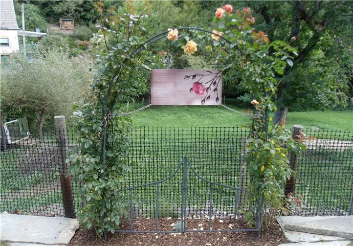 Auf einem Schild des Rosenbogens ist eine Geschichte zu lesen.