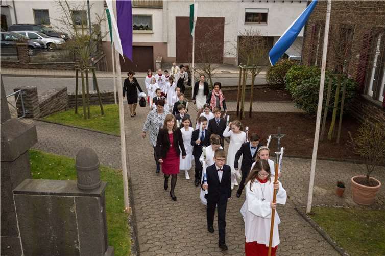 Auf ihrem Weg zur Kirche wurden die Kommunionkinder aus Macken, Brodenbach und Burgen von Pfarrer Wagner, Messdienern und ihren Katechetinnen begleitet. Foto EP