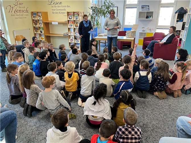 Aufmerksam verfolgen die Grundschüler der Joseph-Kehrrein-Schule in der Montabaurer Stadtbibliothek die Verlosung, die Klaudia Zude und Susanne Walter-Hahn durchführten. Anschließend lauschten die Kinder der Lesung von Ursula Kingen (v.li.). Foto: Stadt Montabaur/Holger Pöritzsch