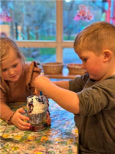 Aus Rasierschaum und Lebensmittelfarbe entstanden bunte Regentropfen in verschiedenen Gläsern, die mit Wasser befüllt waren. Quelle: Kita Auenwiese Raubach
