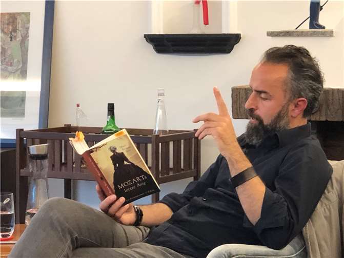 Aydin Isik liest in einem privaten Wohnzimmer.  Foto: Rheinbach liest