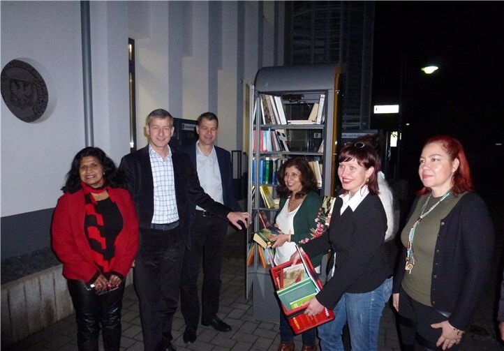 BMI-Mitglieder am Bücherschrank vor der Schlossberg Halle bei der Bücherübergabe an den Ortsbürgermeister. v.li.n.re.: Grace Dahmke, Bürgermeister Michael Dötsch, 1. Beigeordneter der VG Ralf Dötsch, Zeynep Begen, Natalja Kreuter und Helena Boehler. privat