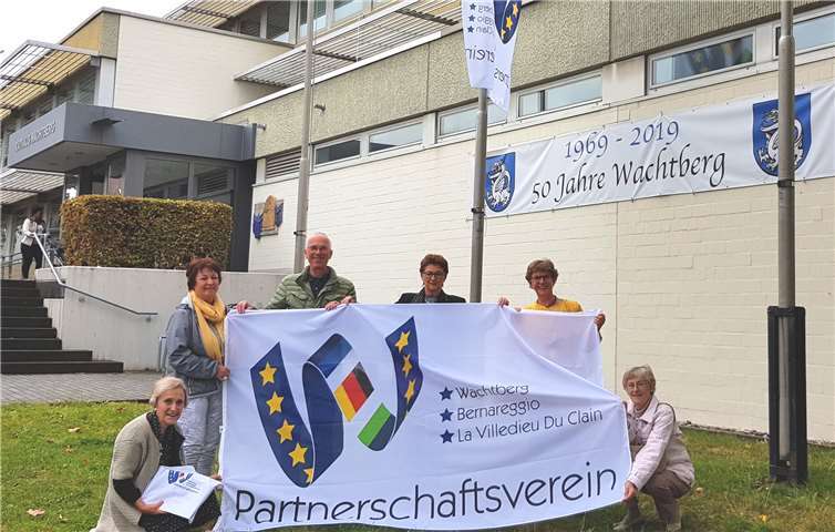 BMin R. Offergeld (3.v.r.), Vereinsvorsitzende Bernadette Conraths (2.v.r.) und Vereinsmitglieder freuen sich über die Fahnen. Foto: Gemeinde Wachtberg/mf