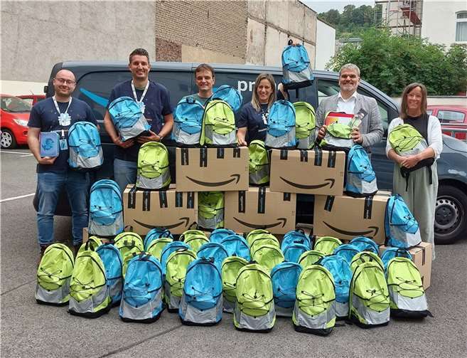 Back to school: Strahlende Gesichter bei der Übergabe der Rucksäcke durch engagierte Amazon-Mitarbeitende. Foto: Marco Wagner