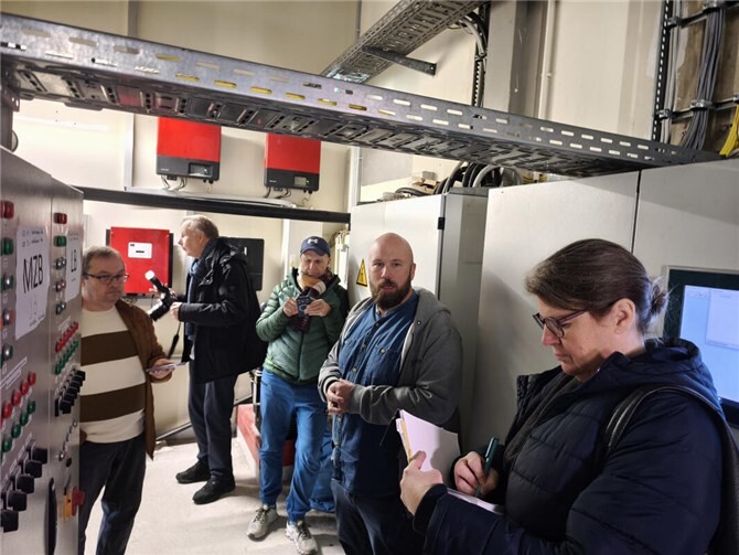 Badleiter Max Grube (2. v.r.) erläutert die Technik des Schaltschrankes.