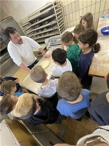 Bäckermeister und Konditor Alexander Nowak mit Kindern aus der Klasse 3b.Foto: Nicole Schumacher