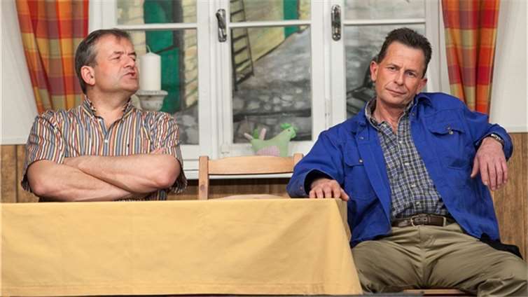 Bauer Karl Hüllen (Wilfried Beusing) und Knecht Hans (Wilbert Goertz) überlegen, wie sie den Jungen unter die Haube bringen können.