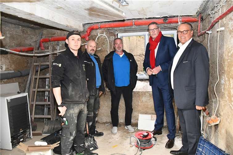 Wiederaufbau Ahrtal als Impulsgeber für regionalen Ausbildungsmarkt Baustellenbesuch in einem Neuenahrer Keller: Projektteilnehmer Justin Langbein (von links) mit Baustellenleiter Patrick Baruch sowie Geschäftsinhaber und Tischlermeister Dirk Roos erklären Arbeitsminister Alexander Schweitzer und HwK-Hauptgeschäftsführer Ralf Hellrich das Schadensbild, die bereits durchgeführten wie noch ausstehenden Arbeiten.