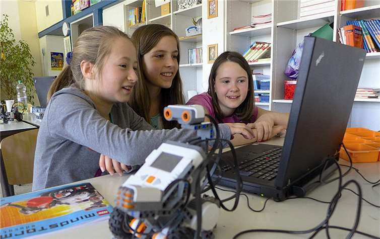 Begeistert arbeiten die Mädchen an der Programmierung ihrer Roboter.