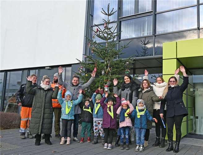 Begeistert nach gelungener Gemeinschaftsarbeit: Die Vorschulkinder der Kita Konfetti und Bürgermeister Jung haben den Weihnachtsbaum vor dem Rathaus festlich geschmückt. Foto: Stadt Meckenheim