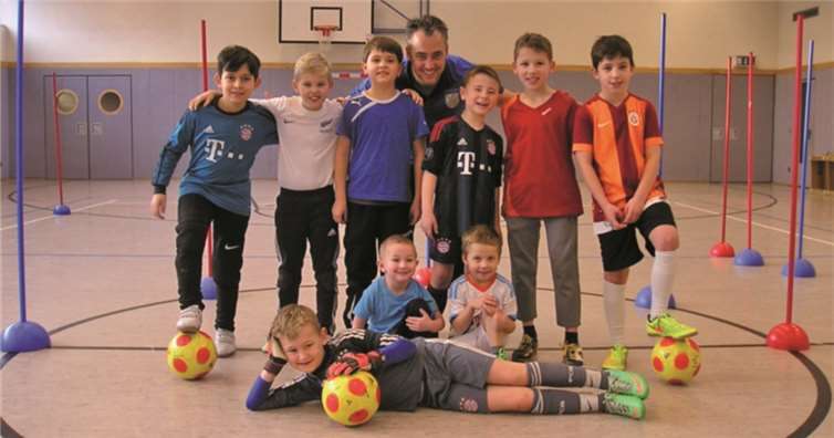 Begeisterte junge Kicker mit ihrem Trainer Steven. privat