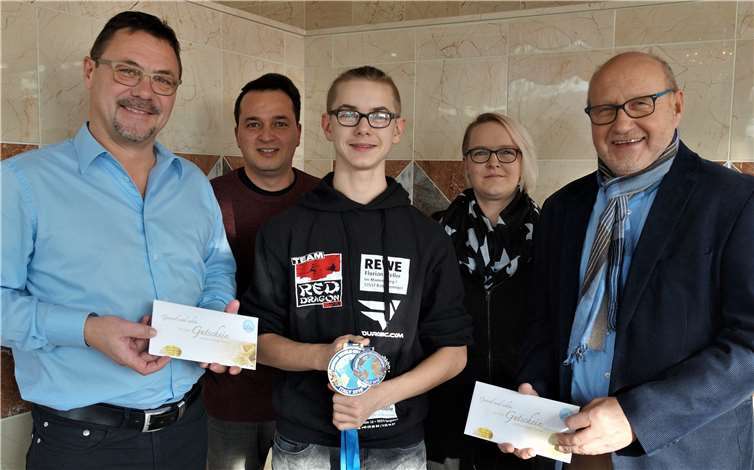 Bei der Ehrung durch die Stadt freute sich Gianluca Bömer (Mitte) mit seinem Trainer und seiner Mutter über die Glückwünsche von Stadtbürgermeister Guido Job (re.) und Dieter Schimak (Betriebsleiter Therme), der Freikarten spendierte. Foto: Privat/Martina Sierocki