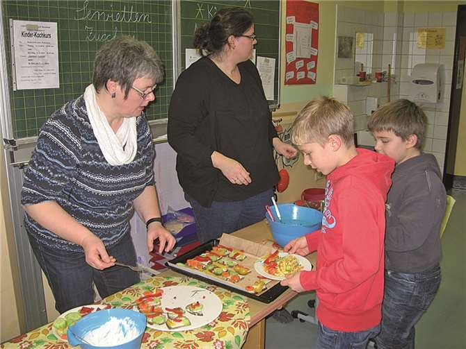 Bei der Essensausgabe bedient Frau Kröll (l.) mit einer Mutter die Kinder und Gäste.privat