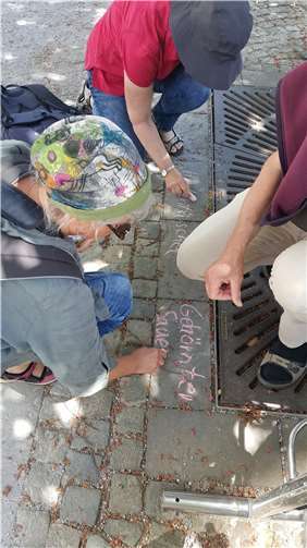 Bei der Krautschau werden Mikro-Ökosysteme entdeckt und bestimmt. Der Name wird mit Kreide auf das Pflaster geschrieben und die Pflanze so für Spaziergänger sichtbar gemacht. Foto: Kreisverwaltung/Jaeger
