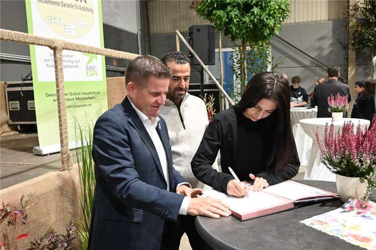 Bei der MeGA-Vertragsunterzeichnung: Eine Schülerin mit ihrem Vater und Bürgermeister Holger Jung. Foto: Stadt Meckenheim