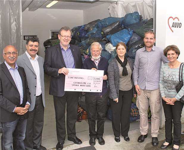 Bei der Scheckübergabe vor der gesammelten Kleidung v.l.n.r.: Musa Ataman, Youssef Klein, beide Kurdische Gemeinschaft, Franz-Josef Windisch, Geschäftsführer AWO Bonn / Rhein-Sieg, Dr. Rupert Neudeck, Ehrenvorsitzender Grünhelme, Mesgin Josef, Jesidischer Rat, Martin Mikat, Vorsitzender Grünhelme und Maria Sido, Gesellschaft für bedrohte Völker. privat