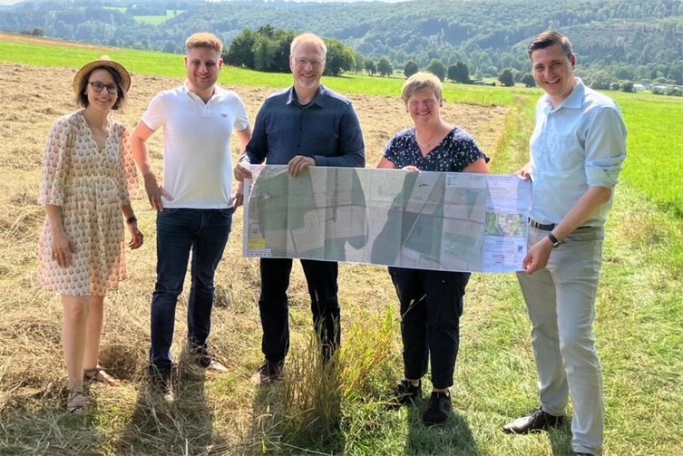 Bei der Sommertour 2025 sahen sich (v.l.n.r.) Susanne Massow, Bürgermeister Marvin Kraus, Harald Orthey MdB, Ortsbürgermeisterin Iris Wagner und Janick Pape MdL vor der offenen Feldlage die Pläne für den Rad- und Wirtschaftsweg an. 