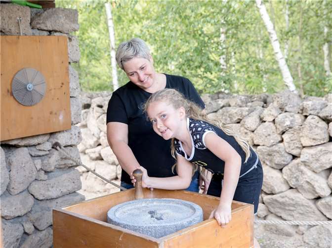 Bei der Themenführung „Mahlen, Kneten, Backen“ kommt auch die römische Handmühle zum Einsatz.Fotos: Vulkanpark GmbH