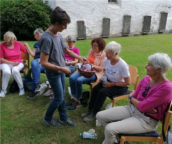 Bei einer Pause im Garten der Evangelischen Kirchengemeinde in Altwied überreichte Heidi Hahnemann den Ehrenamtlichen ein kleines Geschenk.  Foto: Hospizverein