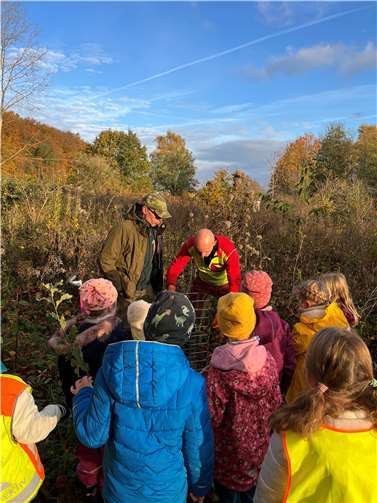 Bei strahlemden Herbstwetter pflanzten die Erstklässler der Waldschule kleine Eichen und Wildkirschen im Stadtwald von Montabaur. Mit dabei waren Revierförster Steffen Koch (l.) und sein Team. Foto: Waldschule