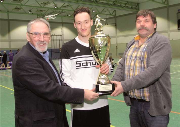 Beigeordneter Jürgen de Temple (li.) und Gerd Stappen von der SG Ahrtal überreichen den wohlverdienten Pokal an Tobias Weiler Spielführer der SG Hocheifel.