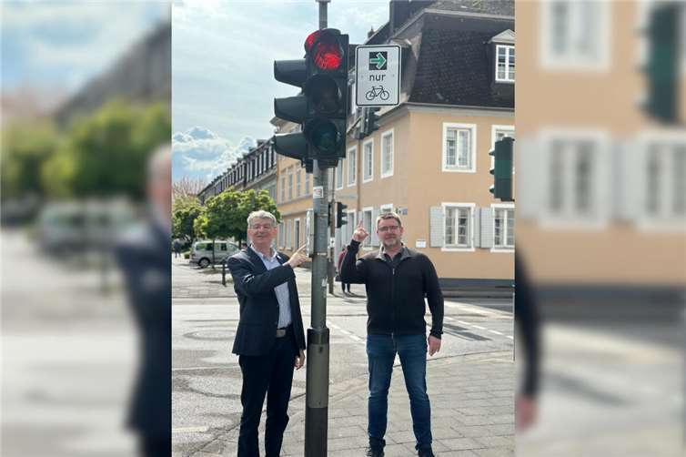 Beigeordneter Ralf Seemann (links) und Andreas Grass vom Ordnungsamt freuen sich, dass an fünf Standorten in der Stadt – wie hier in der Friedrichstraße – alle Voraussetzungen erfüllt werden konnten, um „grüne Pfeile für Fahrradfahrer“ zu installieren.Foto: Stadt Neuwied/Ulf Steffenfauseweh