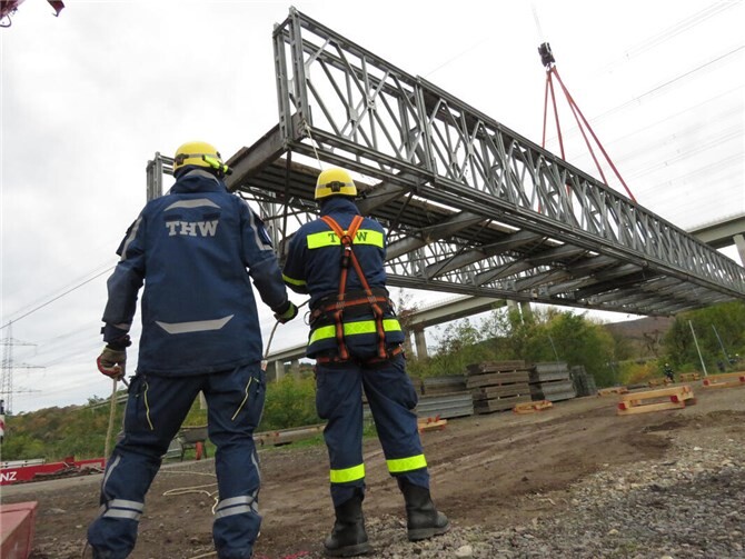 Beim Aushub sichern zwei THW-Einsatzkräfte die Behelfsbrücke.  Foto: THW Ahrweiler, Arnulf