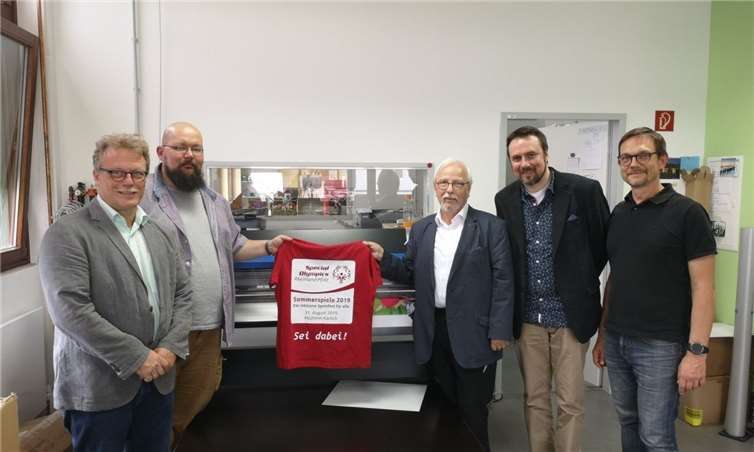 Beim Rundgang in der Rhein-Mosel-Werkstatt von Franz-Robert Herbst (dritter von links) und Joachim Rohde (vierter von links) von der Lebenshilfe Neuwied stellten RMW-Geschäftsführer Thomas Hoffmann (erster von links) und RMW-Produktionsleiter Erik Wirtz (vierter von links) T-Shirts für Special Olympics 2019 vor, deren Druck von der Werkstatt hergestellt und gesponsert wird.