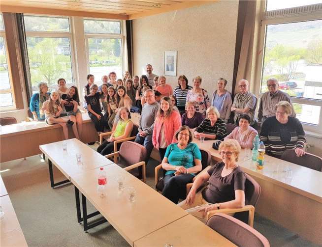 Beim Smartphone-Kurs sind Schülerinnen die Lehrer und die Seniorinnen und Senioren passen aufmerksam auf.