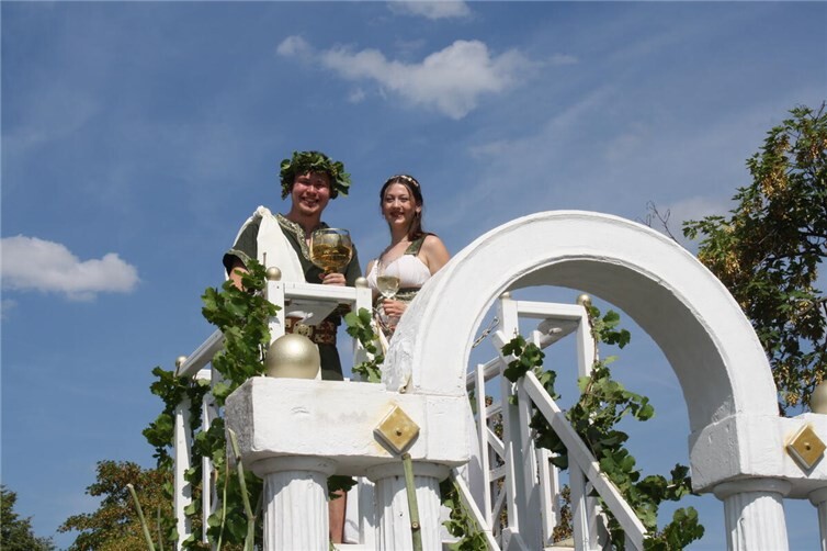 Beim traditionellen Weinfestumzug in Klotten grüßen Bacchus Leon und seine Bacchantin Klara  aus luftiger Höhe.