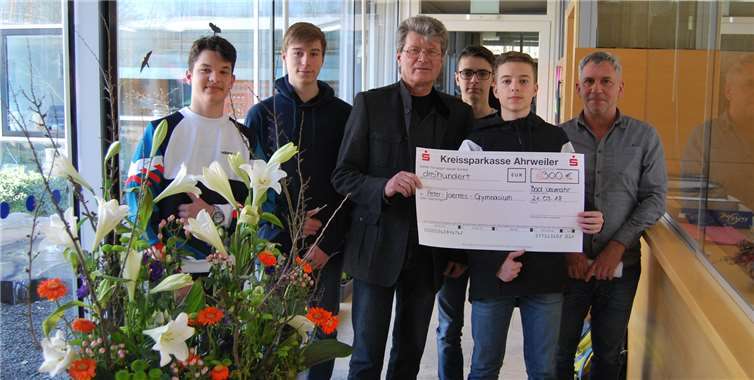 Ben Kühne, Simon Monreal, Luca Molitor und Peter Hilger (v.l.) aus der 10b des PJG unterstützt von ihrem Sozialkundelehrer Willy Buss, überreichen dem Schulleiter Reiner Meiner einen Scheck von 300 Euro für soziale Zwecke der Schule. Privat
