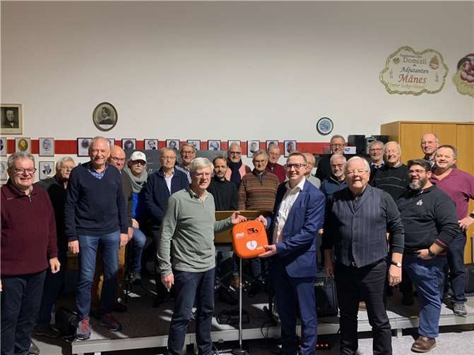 Benjamin Christen Filialleiter der VR-Geschäftsstelle Linz übergibt bei einer Probe den Defibrillator. Vorsitzender Hans Schmitt bedankt sich für die großzügige Spende.  Foto: Stefan Klein