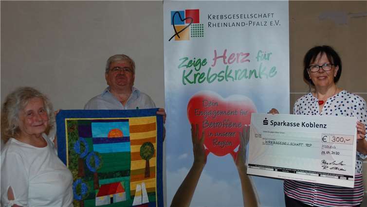 Beratungsstellenleiterin Gerti Kunz (rechts) mit Rolf Erlewein, Verwalter der Herz-Jesu-Kirche, und Quilterin Helga Marake-Maxeiner bei der Spendenübergabe in der Herz-Jesu-Kirche.Foto: Krebsgesellschaft Rheinland-Pfalz e.V.