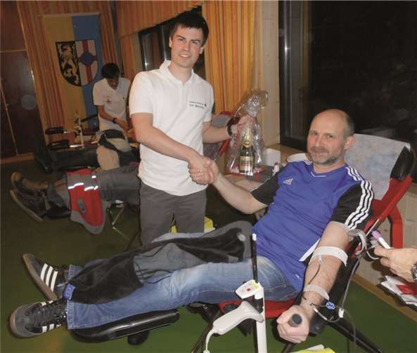 Bereitschaftsleiter Philip Fischer überreichte Stefan Wissen aus Bell als 100. Blutspender eine Flasche Sekt. privat