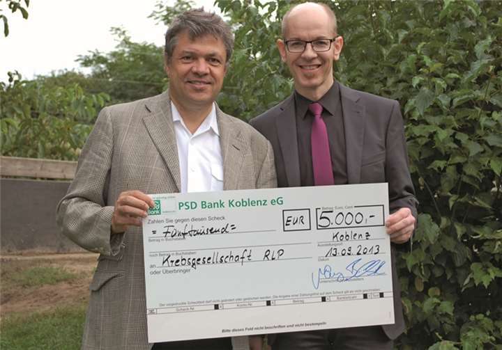Bernd Schittler (rechts), Vorstandsmitglied der PSD Bank, übergab im Rahmen der Auszeichnung des ersten Sonnenschutzkindergartens in Koblenz einen Spenden-Scheck in Höhe von 5.000 Euro an den Vorsitzenden der Krebsgesellschaft Rheinland-Pfalz, Herrn Prof. Dr. Dr. Richard Werkmeister.Krebsgesellschaft Rheinland-Pfalz e.V.